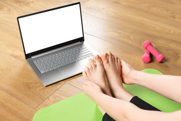 人适合运动健康的女人坐在垫子上 在paschimottanasana姿势 做呼吸练习 看在线瑜伽课上的模拟笔记本电脑网络技术瑜伽工作室
