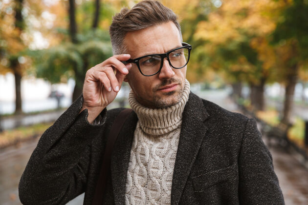 大道欧洲男人30多岁的眼镜照片 走在户外穿过秋天的公园胡须休闲夹克