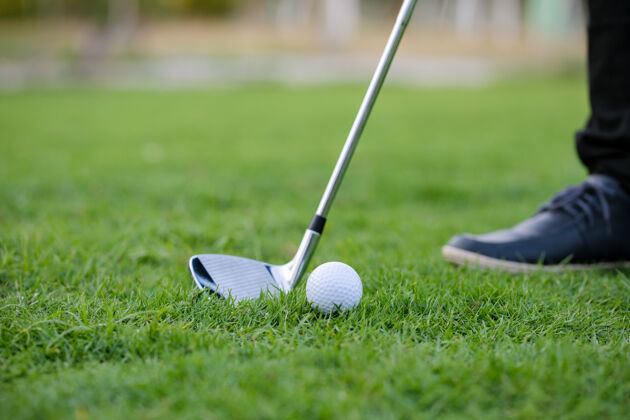 高尔夫高尔夫俱乐部和高尔夫球在一个美丽的高尔夫球场绿色草坪与上午活动草地游戏