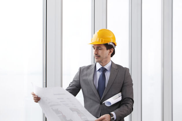 业务员戴着安全帽 穿着西装 带着建筑图的建筑师业务工程师人