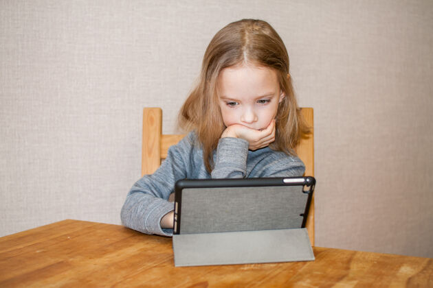 可爱小女孩正在看在线视频教程.远程培训.blog.high高质量的照片棒课人