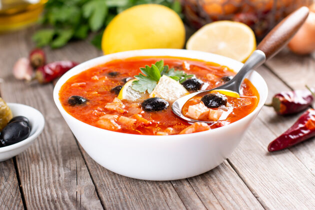 蔬菜传统的俄罗斯肉汤在乡村木桌上的碗里橄榄鱼午餐
