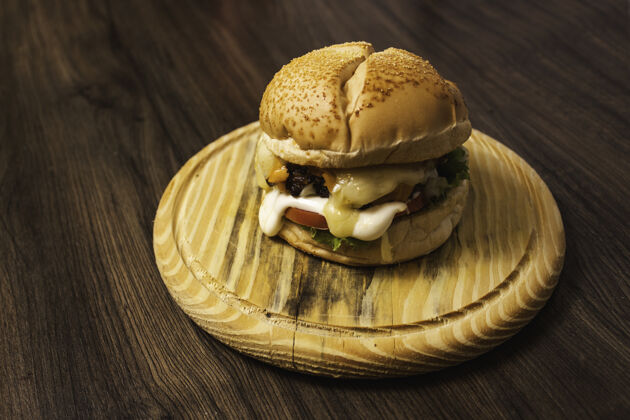 小吃一个美味的汉堡包 在木盘上放着不同种类的奶酪平底锅肉牛肉