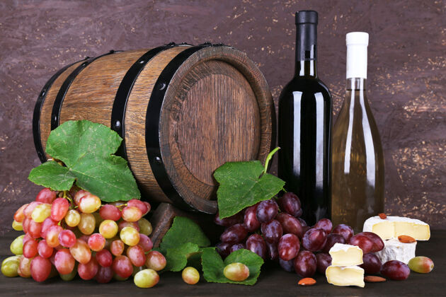 木头酒瓶 卡门伯特和布里干酪 葡萄和木桶放在木制背景的木制桌子上图片葡萄酒杯子