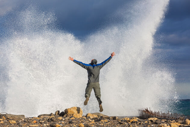 情绪人在戏剧性的风暴波中跳跃海浪运动员天气