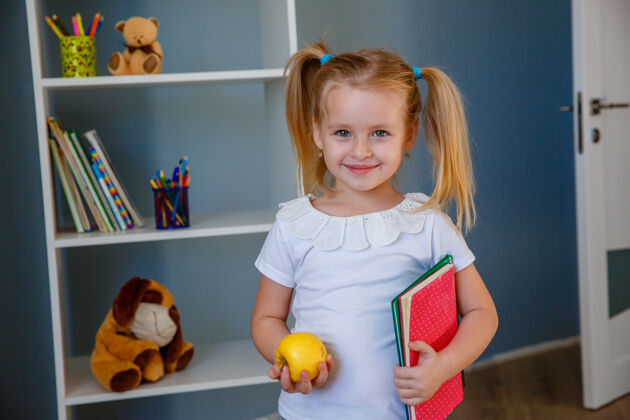 小一个手里拿着书和苹果的小女孩苹果快乐女孩