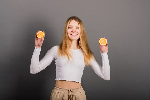 刷新微笑的女人吃橘子 半个水果 长头发工作室射击饮食白色切片