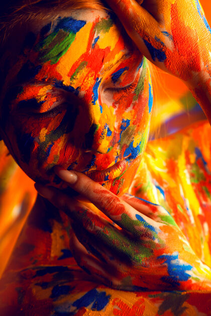 人皮肤上涂着彩色颜料的女人脸红色人体艺术