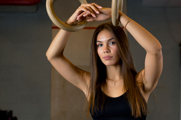 肖像在健身房里 一位长发迷人的女士站在一位教练旁边 双手合十强壮活动运动