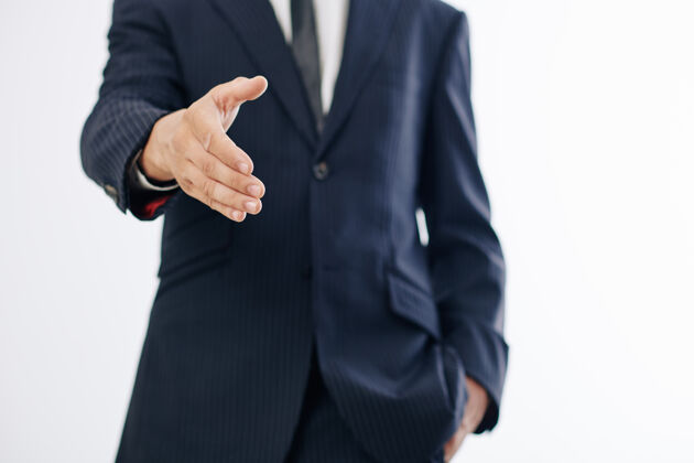 高管在问候同事时 企业家伸出手来握手的剪短图像年轻人吸引力领带