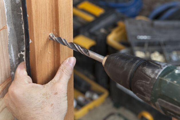 装配安装内门 电钻特写 在木架门柱上钻孔修理设备安装