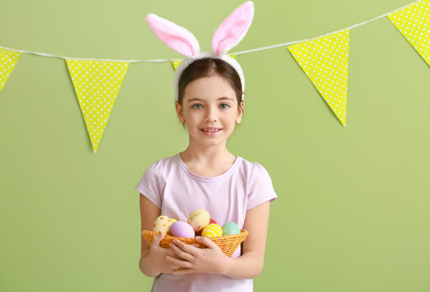 鸡蛋可爱的小女孩和兔子耳朵和复活节彩蛋表面人礼物狩猎
