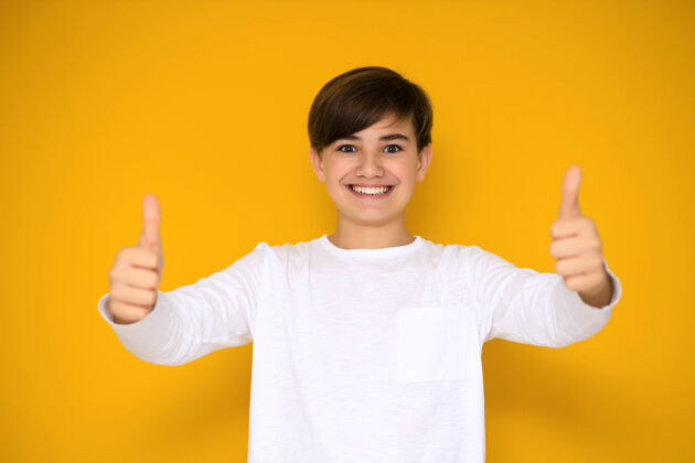 孩子黄色背景上一个12-13岁的英俊少年的画像吸引力休闲手