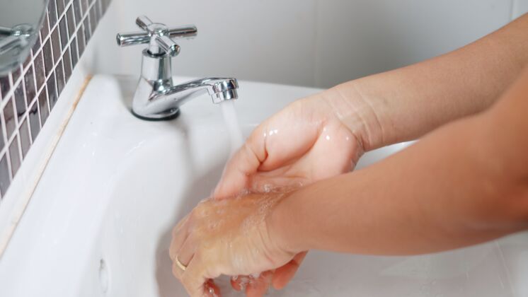 卫生用肥皂洗手 在水龙头下洗手女人人水
