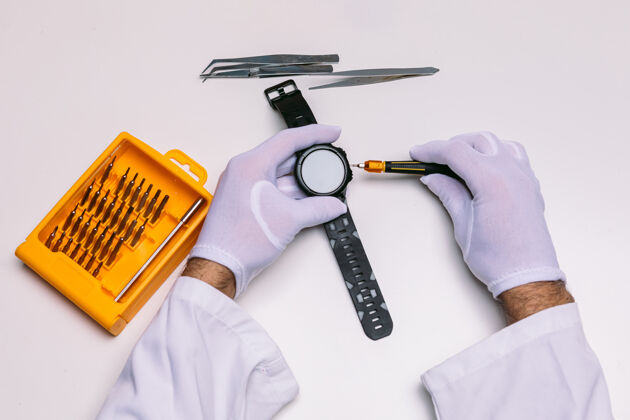 电子一个戴着手套的技师的手在修理一个手表智能手表数码手表技师