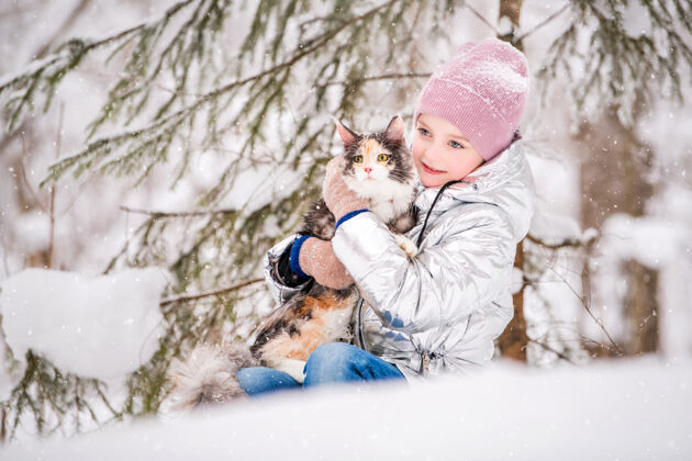 胡须在冬天的森林里 小女孩抱着一只猫坐在雪地里霜冻朋友国内