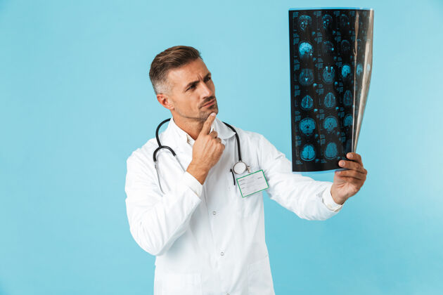 文件带听诊器的医学专家的肖像 手持x光片 孤立地站在蓝色的墙上专业知识制服职业