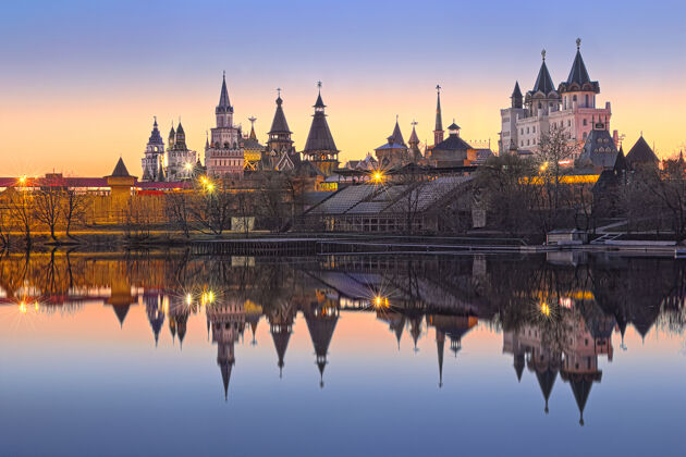 城市景观莫斯科伊兹梅洛夫斯基克里姆林宫的特里姆基在傍晚的灯光下倒映在池塘的水中景观建筑灯笼