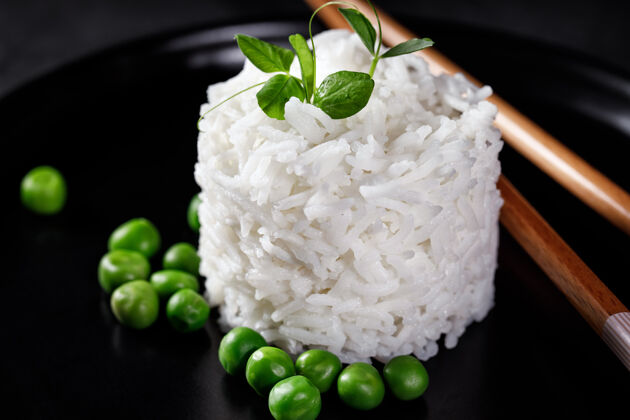 健康一碗煮熟的白色长粒米饭的头顶照片 从上面拍摄 背景为蓝绿色 有一个地方放文字原味茉莉欧芹