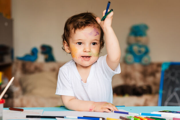 小学可爱的小男孩拿着彩色铅笔和马克笔纸小小