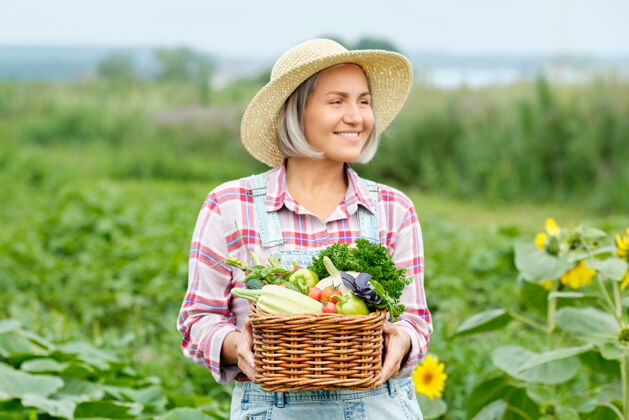 南瓜女人手里拿着一篮子丰收的有机蔬菜和根上的有机生物农场.秋天蔬菜收获季节生物萝卜