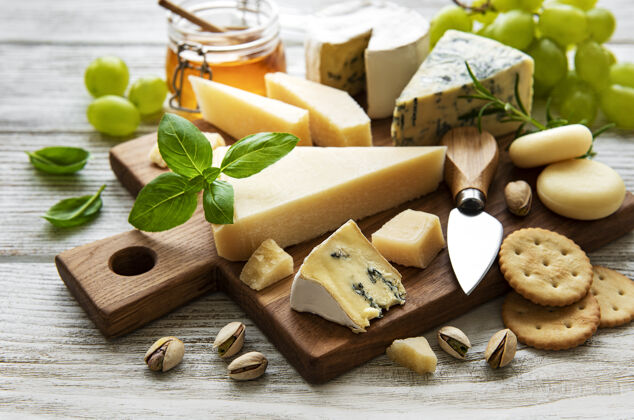 坚果白色木桌上摆着各种各样的奶酪健康不同产品