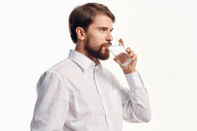 背景一个男人的肖像用一杯水喝冷却光背景衬衫模型透明英俊清洁