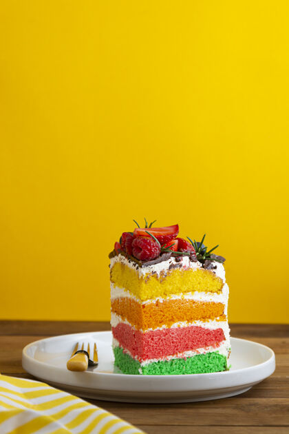 生日彩虹蛋糕与新鲜浆果黄色背景夏天五颜六色装饰