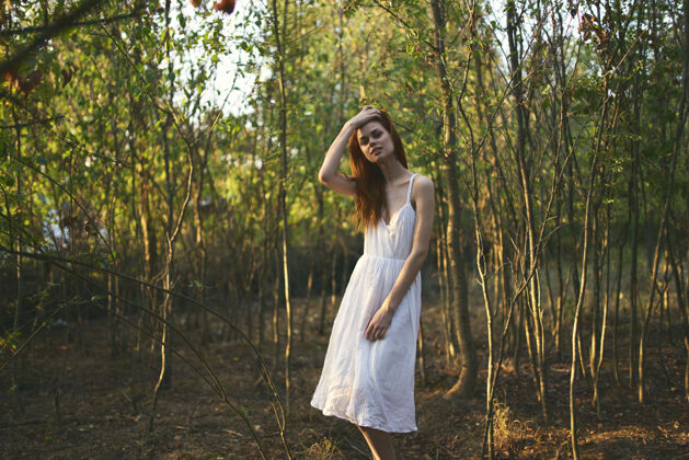 自然花园里树旁的女人穿着白色的衣服 过暑假自然树公园新鲜