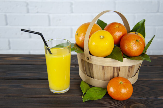 甜一篮柑橘类水果和一杯果汁健康玻璃篮子