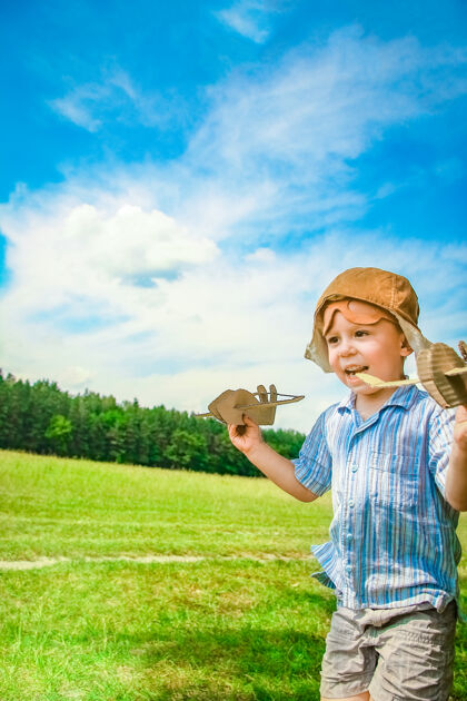 人飞机旁的一个男婴在空中玩弄大自然公园男孩度假飞行员小游戏活跃