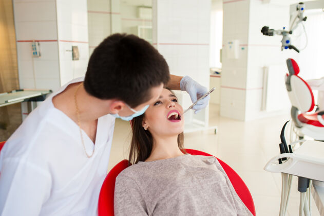 快乐牙医正在治疗一个漂亮女孩的牙齿治疗客户年轻