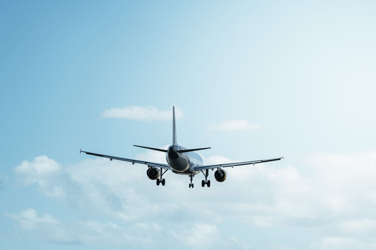 航空公司在晴朗的蓝天上飞行的后视图航空机场旅程