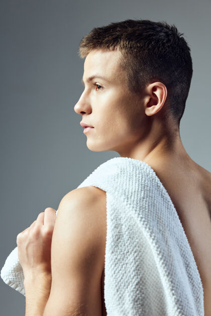 肌肉帅哥背着毛巾 背景是灰色的年轻男体操