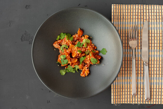 烹饪炸鸡和花生酱在黑色陶瓷碗顶视图东方菜亚洲菜花生