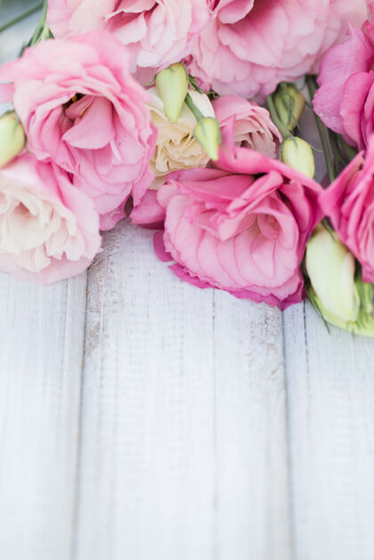 植物木桌上的粉红色鲜花架束明亮特写