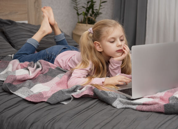 远程金发女孩在家上网学习 床上放着笔记本电脑技术工作场所微笑