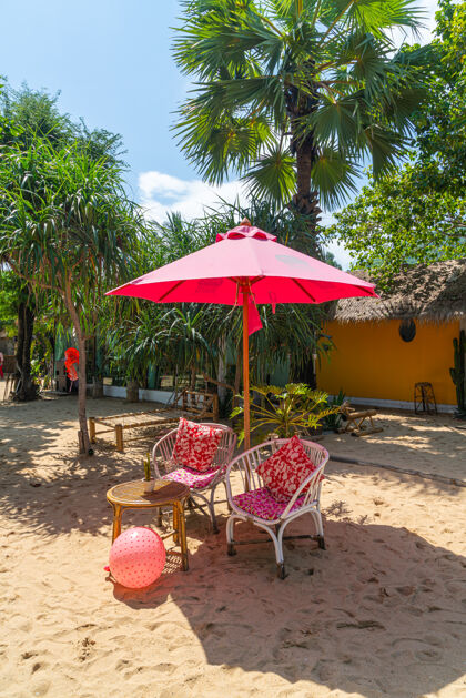 享受热带海滩上的粉色雨伞和椅子休息室舒适海岸
