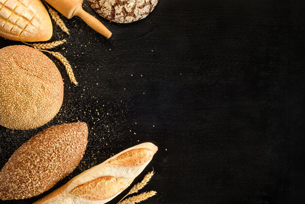 有机不同种类的面包放在一个黑面包上背景.top查看铺设乡村食物
