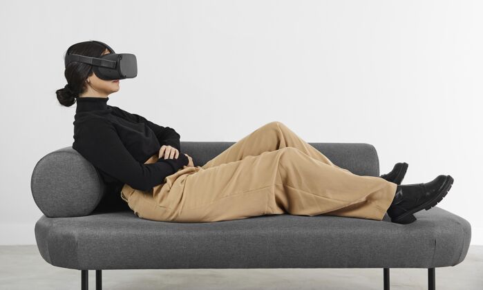 设备沙发上戴着虚拟现实耳机的女人女人小玩意室内