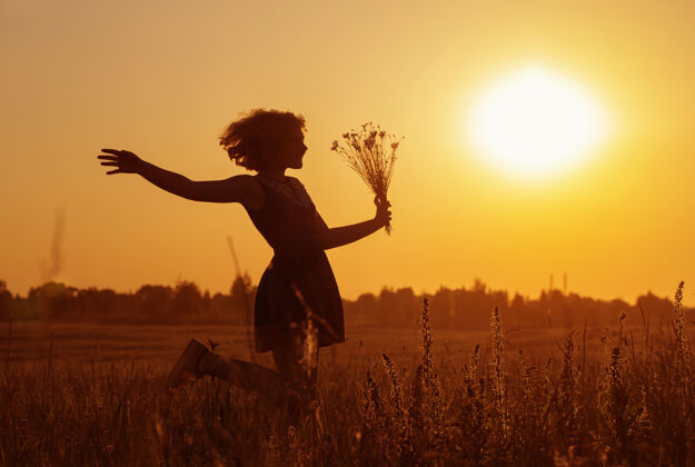 牛仔裤美丽的少女在夏天的田野与矢车菊风景花束乡村