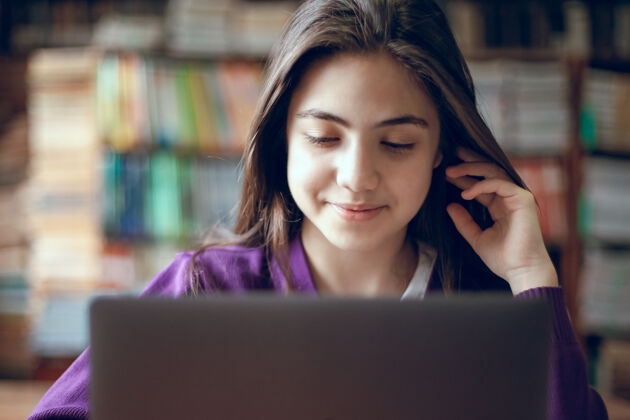 学校漂亮的女生在学校图书馆用笔记本电脑学习学生学习搜索