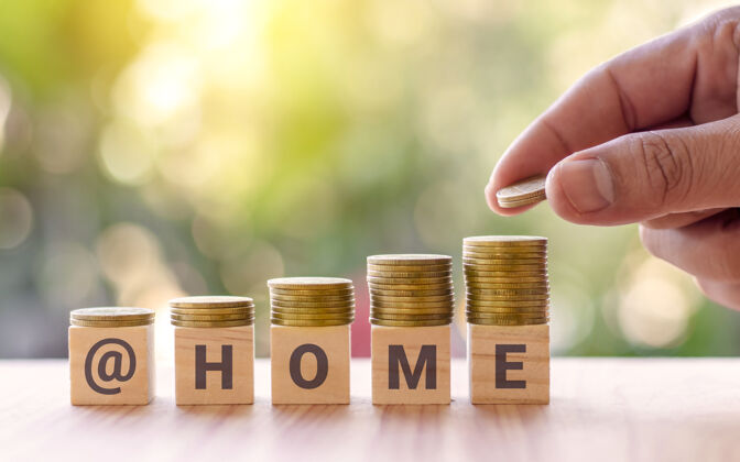 金融手拿空硬币和方形木块 上面写着“家 从家做起”的字样冠状病毒经济现金