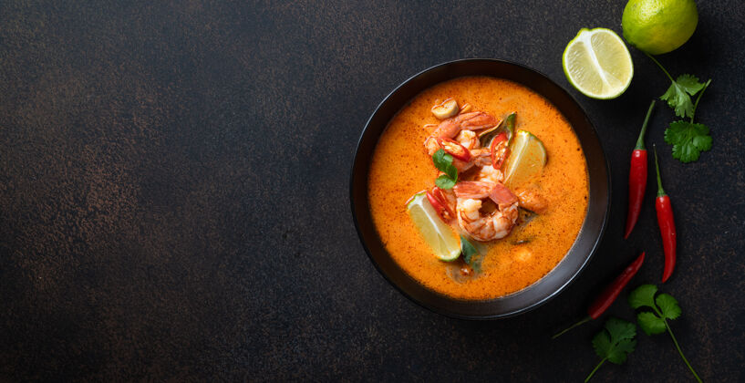 亚洲汤姆山贡麻辣泰国汤虾在一个黑色的碗在一个黑暗的石头背景 顶视图 复制空间辣复制空间食物