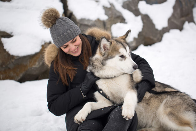 家庭冬天森林里美丽的女孩狗玩和狗西伯利亚哈士奇可爱森林女孩
