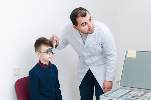 孩子眼科医生在检查眼睛专家父母眼镜商