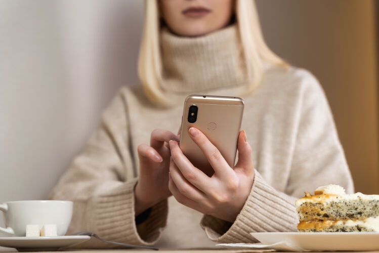 健康严肃的女人看着智能手机在咖啡馆查看新闻保护室外护理