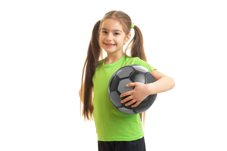活跃一个手里拿着足球的小姑娘 脸上露出孤立的笑容青少年可爱球