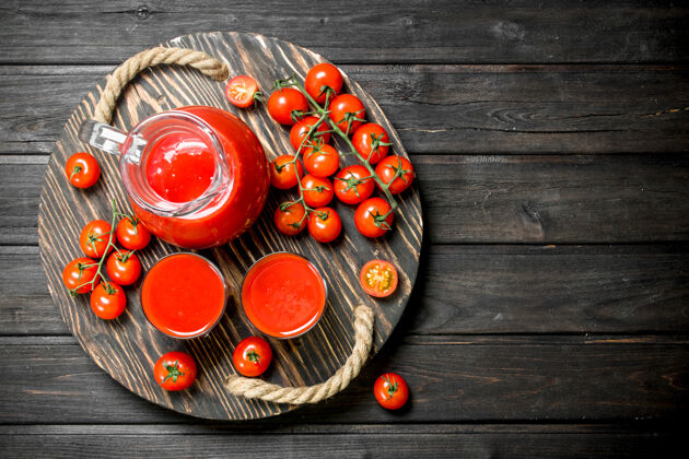 甜味番茄汁在罐子里放在托盘上 番茄放在盘子上分支机构木制背景营养填料血腥