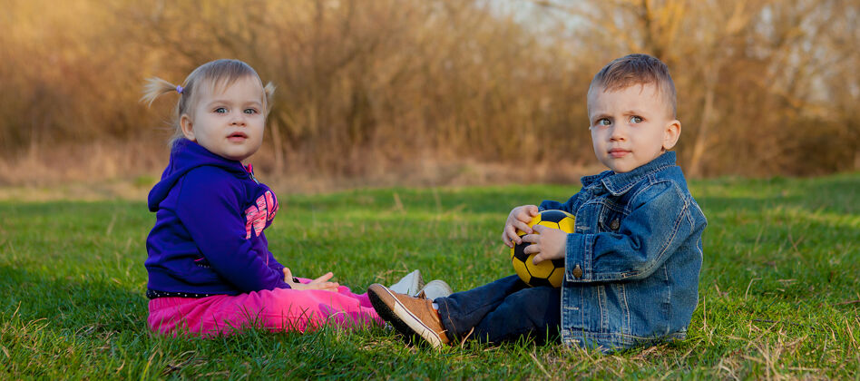 女性两岁的男孩和女孩在春天的玻璃上笑自然爱女孩